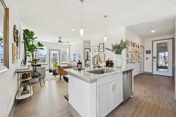 A modern kitchen with a large island and a dining area.